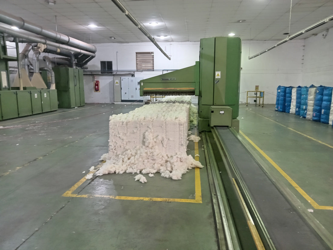 Raw cotton bale being fed into processing machinery