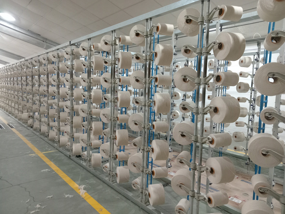 Rows of cotton yarn spools on factory racks