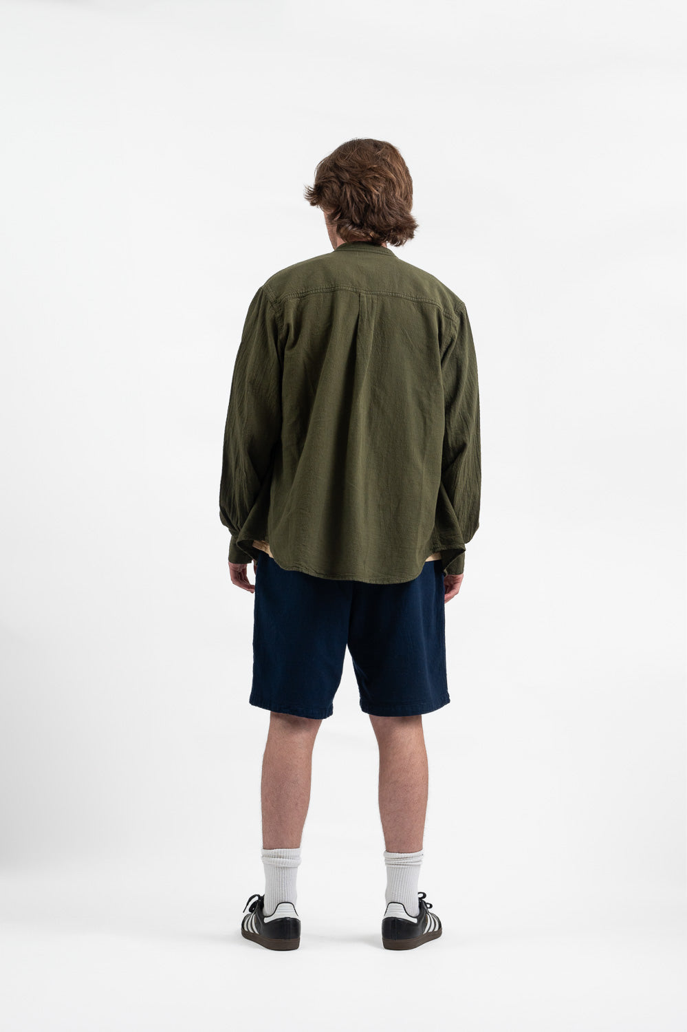 Model wearing Utku Fabián Shirt in Olive green — tagua nut buttons