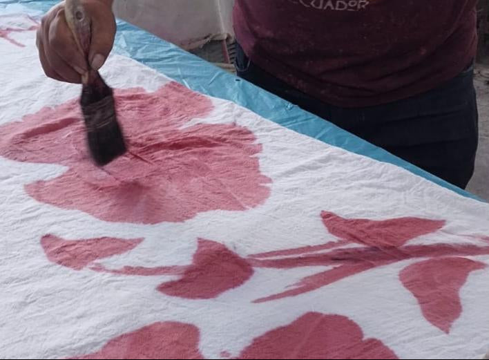 UTKU artisan sketching the floral design onto the dress fabric before painting