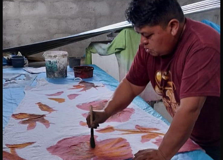 UTKU artisan applying non-toxic dye by hand to the floral pattern
